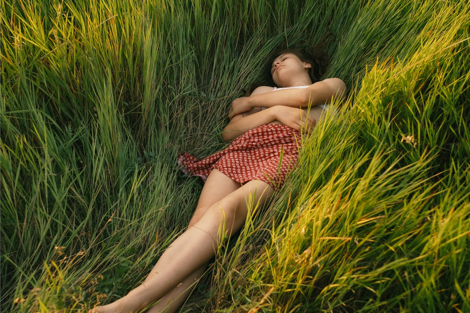 Someone lying barefoot in long summer grass